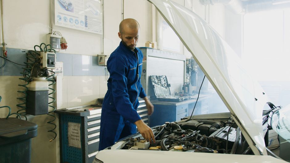 Mechanik kontroluje stav motora vozidla